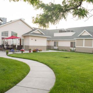 A residential house with a well-maintained lawn and a curved concrete pathway.