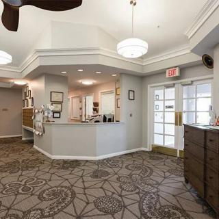 A well-lit lobby area featuring a reception desk and decorative carpeting.