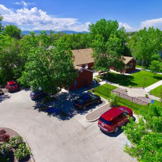 Aerial view of a serene residential area surrounded by lush greenery and a clear blue sky.