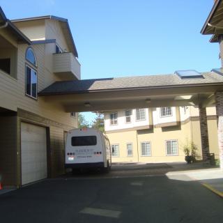 A residential building with an RV parked in the courtyard.