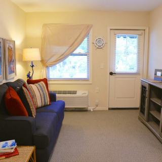 A cozy living room with a sofa, side lamp, and window light.
