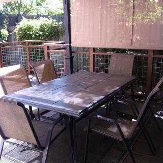 A shaded patio area with a table and chairs.