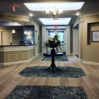 A modern lobby with elegant interior design, featuring a floral arrangement and chandeliers.