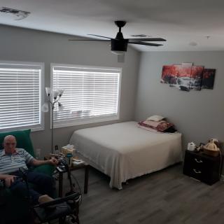 A cozy bedroom with a bed, chair, and decorated walls.