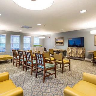 A cozy meeting room with arranged seating and a television.