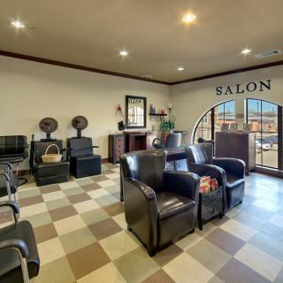 A cozy salon with a checkered floor, featuring chairs for waiting and hair styling, along with a reception desk.