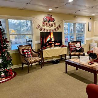 A cozy and festive living room adorned with Christmas decorations, complete with a fire screen and holiday spirit.