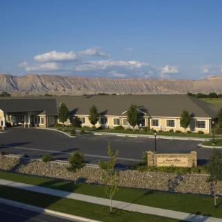 A scenic view of a building with a mountainous backdrop and clear sky.