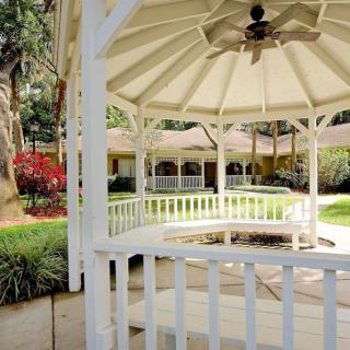 A white gazebo in a well-maintained garden setting.