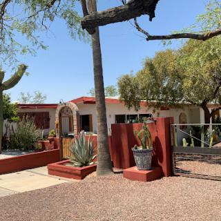 A charming desert home surrounded by native plants and a serene outdoor space.