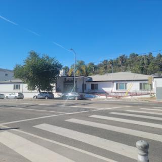 A view of residential houses along a street with a crosswalk under a clear blue sky.