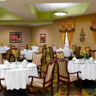 A well-decorated dining area with multiple round tables and chairs, ready for guests.