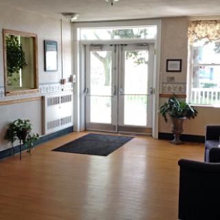 A bright and welcoming lobby area featuring a clean entrance, comfortable seating, and decorative plants.