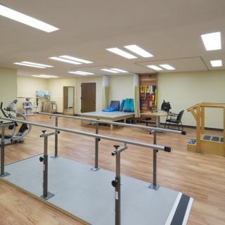 A spacious physical therapy room equipped with various rehabilitation equipment.
