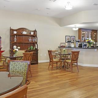 A cozy cafe interior with wooden tables and chairs, complemented by elegant decor and a welcoming atmosphere.