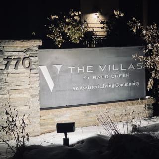 Night view of a residential sign reading 'The Village'.