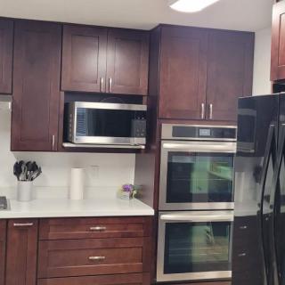 Modern kitchen with dark wood cabinets and stainless steel appliances.