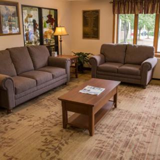 A cozy living room with two sofas, a wooden coffee table, and warm decor.