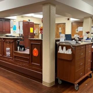 A reception area with wooden desks and office equipment.