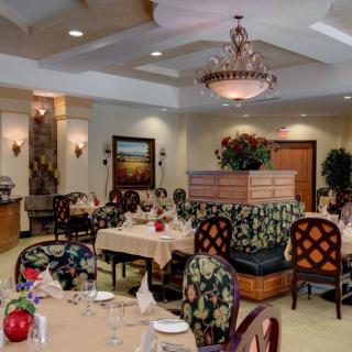 An elegant restaurant interior with a chandelier, well-arranged tables, and stylish decor.