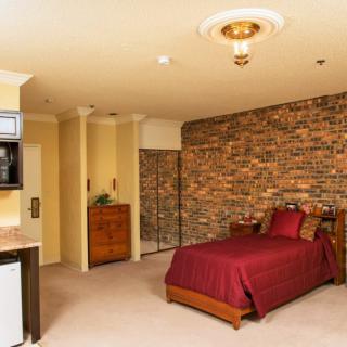 A cozy bedroom with a warm brick accent wall and elegant furnishings.