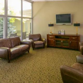 A cozy living room with leather seating and a wall-mounted TV.