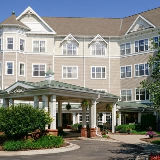 A large residential building with a landscaped entrance and classic architectural design.