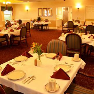 An elegantly set dining room with neatly arranged tables and chairs.