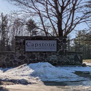 The entrance sign for Capstone surrounded by a snowy landscape.