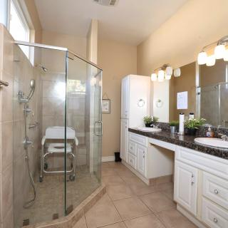 A modern bathroom with a glass-enclosed shower and a double sink vanity.
