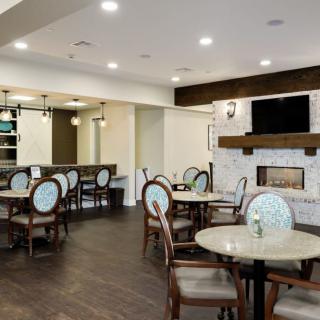 A modern dining area with elegant seating, a fireplace, and a television.