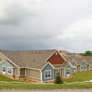 A row of suburban houses under a cloudy sky.