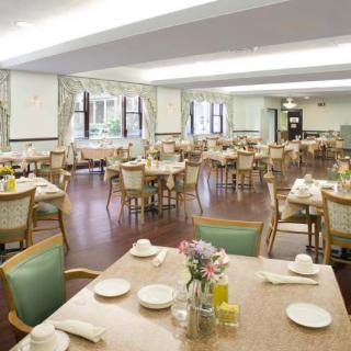 An elegantly decorated dining area with neatly arranged tables and chairs, set for a meal.