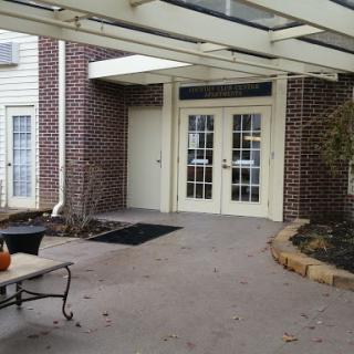 A view of the entrance area featuring double doors and a landscaped path.
