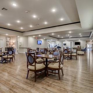 A spacious and modern dining area with elegant wooden furniture and bright lighting.