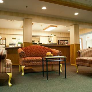 A cozy lobby area featuring classic upholstered furniture and warm lighting.