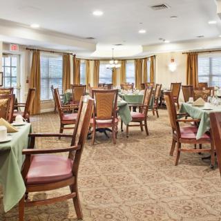 A well-arranged dining room with tables and chairs set for a meal.