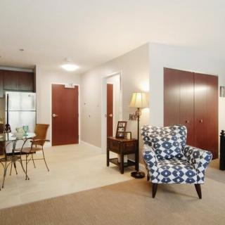 A modern living room with a patterned armchair, dining table, and stylish decor.