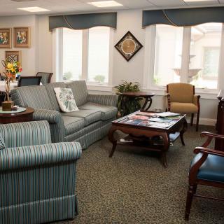 A cozy living room with a sofa, armchairs, and a coffee table, decorated with various decor items.