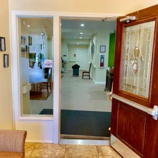 A welcoming entrance to a building featuring a glass door and an inviting lobby.