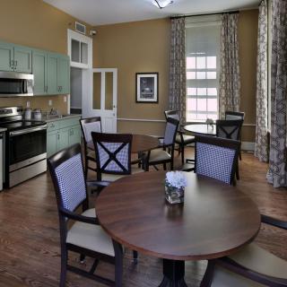 A cozy dining area with a kitchen, featuring a round table and chairs.