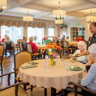 Residents enjoying a meal together in a senior living dining area.
