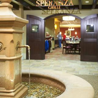 Entrance to Speranza Grille featuring an elegant fountain and inviting dining area.