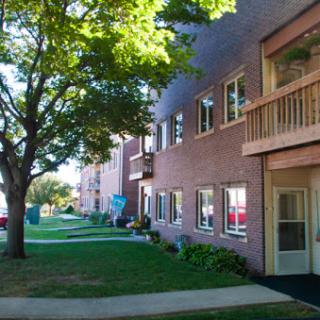 A serene view of a residential apartment building surrounded by greenery.
