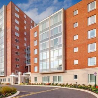 A modern residential building with red brick and large windows.