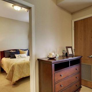 A cozy bedroom with a wooden dresser and an inviting bed.