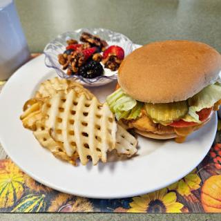 A delicious meal featuring a burger, waffle fries, and a side salad.