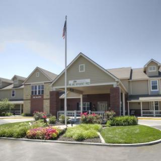 A well-maintained building with a landscaped garden and an American flag at the entrance.