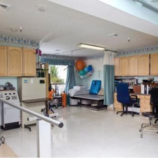 A medical clinic room equipped with various healthcare devices and furniture used for treatment and examinations.
