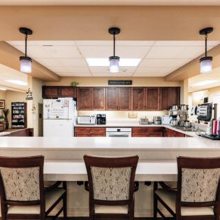 A modern kitchen interior with a large countertop and dining chairs.
